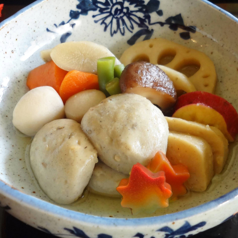 秋の根菜と五穀麸を煮いたんに。五穀麸は、五つの穀物(大豆・大麦・ごま・玄米・キヌア)を練り込んだ『五穀豊穣』の秋のお麸です。プチプチとした食感をお楽しみください。もみじ麸を散らせば、食卓に秋の風が舞い込みます
